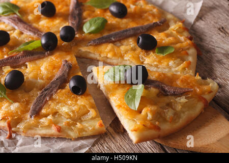 Französische Pizza mit Sardellen und Zwiebeln Nahaufnahme auf dem Tisch. Horizontale Stockfoto