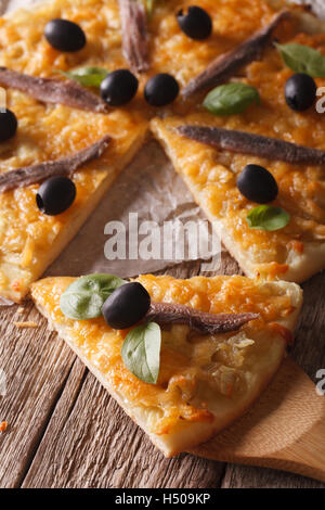 Französische Pizza mit Sardellen und Zwiebeln Nahaufnahme auf dem Tisch. vertikale Stockfoto