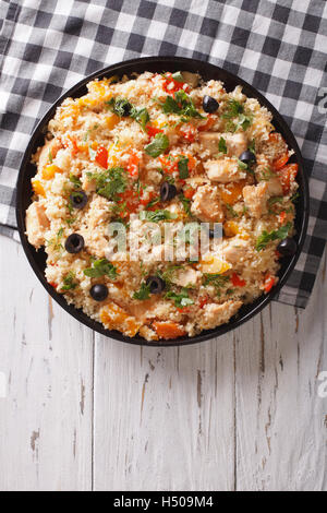 Couscous mit Huhn, Oliven und Gemüse auf den Tisch. vertikale Ansicht von oben Stockfoto