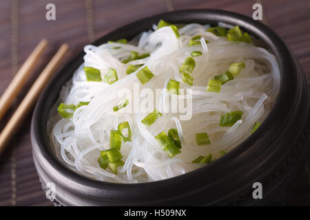 Chinesischer Reis Nudeln mit Frühlingszwiebeln-Makro in einer Schüssel auf dem Tisch. horizontale Stockfoto