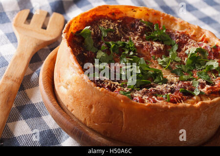 Würzige Chicago deep Dish Pizza Closeup auf einem Teller auf den Tisch. horizontale Stockfoto