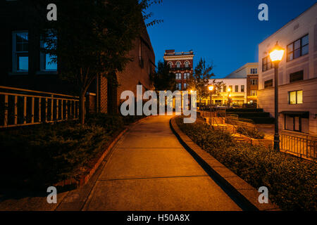 Gehweg und Gebäude in der Nacht in der Innenstadt von Rock Hill, South Carolina. Stockfoto