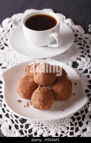 Schokoladen-Trüffel mit einer Untertasse Großaufnahme auf dem Tisch. Vertikal Stockfoto