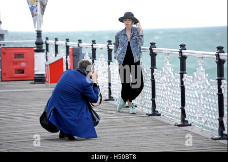 Ein Fotograf fotografiert attraktive junges weibliche Modell tragen Jeans Jacke und Hut-Mode Stockfoto