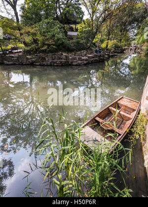 Kleine chinesische Holzboot mit reflektierten Bäume im Garten des bescheidenen Verwalters, Suzhou, China Stockfoto