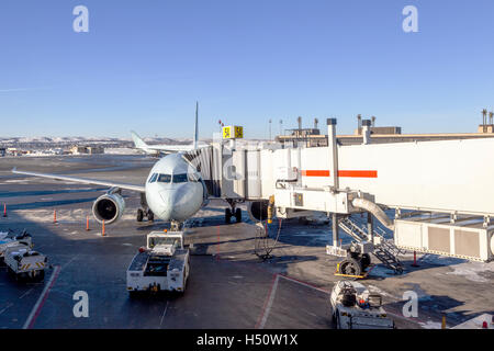 Ein Passagierflugzeug mit einer Fluggastbrücke am Flughafen-Gate von bedient verbunden. Stockfoto