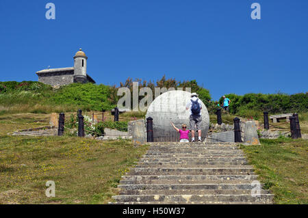 Frau wird vor dem riesigen Steinglobus im Durston County Park, Isle of Purbeck, Swanage, Dorset, England fotografiert. Stockfoto