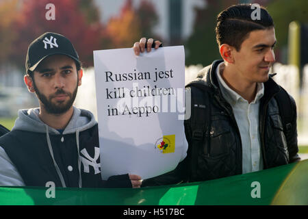 Berlin, Deutschland. 19. Oktober 2016. Syrische Demonstranten halten ein Plakat vor dem Bundeskanzleramt in Berlin, Deutschland, 19. Oktober 2016. Foto: Paul Zinken/Dpa/Alamy Live News Stockfoto