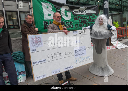 London, UK. 19. Oktober 2016. Eine Frau, gekleidet wie ein Kühlturm an die Proteste durch die Axt Drax-Kampagne auf der International Day of Action auf Biomasse außerhalb der neuen Dept of Business Energy und Industriestrategie präsentiert mit einem Scheck für die staatlichen Subventionen im Jahr 2015 von 450 Mio. GBP. Demonstranten fordern die Regierung auf, die wissenschaftliche Forschung, die zeigt, dass die Erzeugung von Strom aus Biokraftstoffen ist schädlich für das Klima, Wälder, Biodiversität und Menschen erkennen und entfernen die Subventionen, die seine Verwendung fördert. Peter Marshall/Alamy Live-Nachrichten Stockfoto