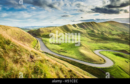 Leere Serpentine Road zwischen grünen Hügeln der Peak District National Park in Großbritannien Stockfoto