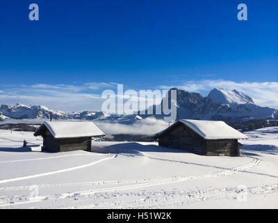 Alte hölzerne Scheunen, umgeben von tiefen Schnee mit Skipisten in den Dolomiten, Italien, Europa Stockfoto