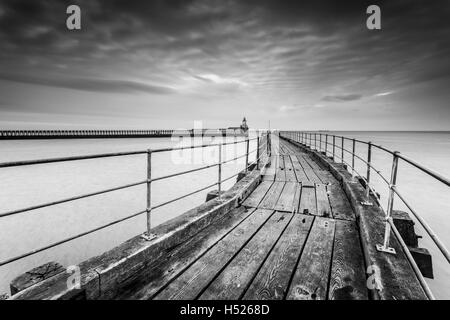Blyth Pier an der Northumberland Küste Blyth Harbour, eine alte geschwungene Holzmole in schwarz und weiß Stockfoto