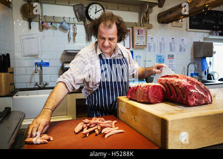 Metzger bereitet ein großes Stück Rindfleisch in eine Butcherer laden. Stockfoto