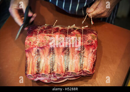 Metzger bereitet ein großes Stück Rindfleisch in eine Butcherer laden. Stockfoto