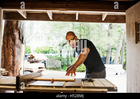 Mann mit Brille arbeiten in einem Holzlager. Stockfoto