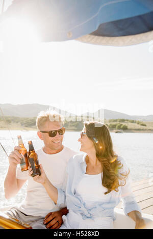 Mann und Frau auf einem Segelboot, mit einem Drink. Stockfoto