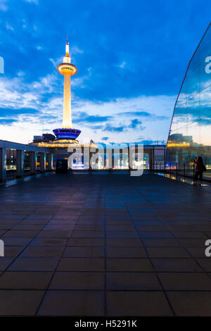 Schöne blaue Stunde Himmel hinter bunten, beleuchteter Kyoto Tower gesehen vom großen Balkon in Kyoto, Japan. Vertikale Textfreiraum Stockfoto
