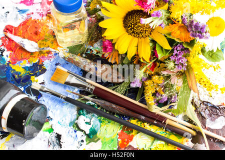 Palette mit Malerei Material und einem Bouquet von Sommerblumen. Stockfoto