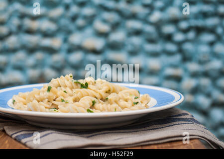 Fusilli Nudeln in weißer Soße mit Basilikum. Stockfoto