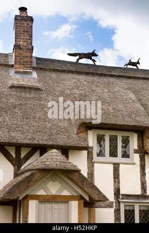 Großbritannien, England, Cheshire, Tiverton, Huxley Lane, Rose Cottage, Fuchs, Kaninchen zu jagen strohgedeckten Dach Dekoration Stockfoto