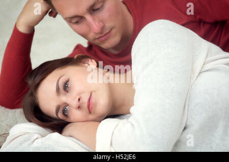schöne junge Paar auf weißen Teppich liegend Stockfoto