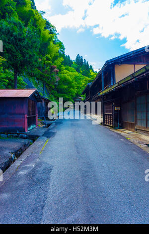 Wald auf der einen Seite, traditionellen Holzhaus auf anderen an diesem Küstenabschnitt der Nakasendo Wanderweg zwischen Poststraße-Tsumango in der Post-Stadt Stockfoto