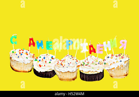 Cupcakes mit Kerzen mit Buchstaben Happy Birthday isoliert. Stockfoto