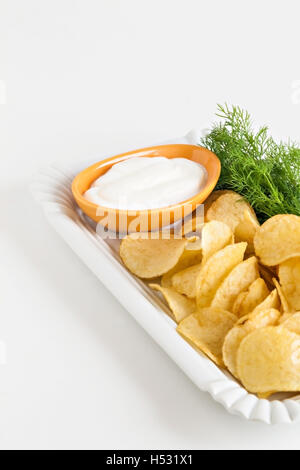 Chips mit Sauerrahm und Dillsauce isoliert. Stockfoto