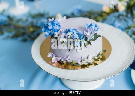 Hochzeitsdekorationen mit Kuchen und Blumen Stockfoto