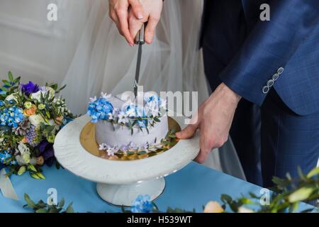 Braut und Bräutigam bei der Hochzeit den Kuchen schneiden Stockfoto