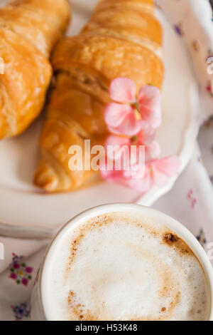 Croissants, Kaffeetasse, blüht im romantischen Stil. Stockfoto