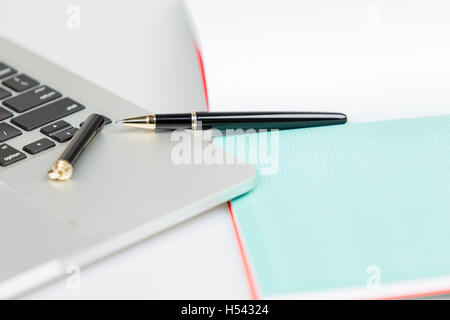 Öffnen Sie Stift und Kappe auf offene Notebook und Laptop liegen. Schuss auf weißem Hintergrund Stockfoto