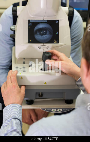 Ein Optiker Sehtest mit Hilfe einer optischen Kohärenztomographie (OCT) Maschine durchführen. Stockfoto