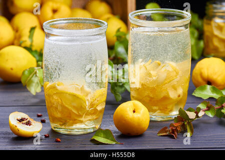 kohlensäurehaltige Getränke mit Sirup aus japanische Quitte auf frisches Obst Hintergrund Stockfoto