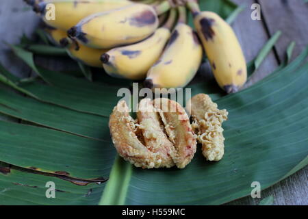 Nahaufnahme von Fried Ducasse Bananen oder auch bekannt als Zucker Bananen auf Bananenblatt und Holzbrett Stockfoto