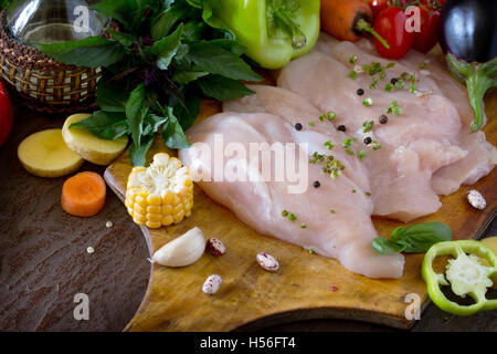 Frisches rohes Hühnchen mit Gemüse auf ein Schneidebrett. Stockfoto