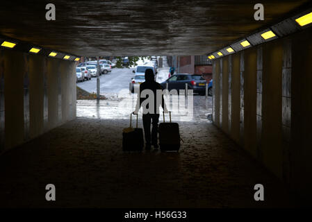 Silhouetten von Menschen in der Stadt Mann mit Gepäck zwei Fälle oder trollys Stockfoto