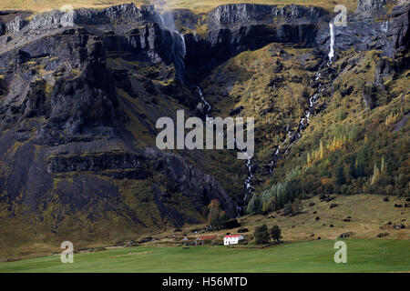 Ländliche Landhaus unter Berg Wasserfall, Ostisland, Nordatlantik, Europa Stockfoto