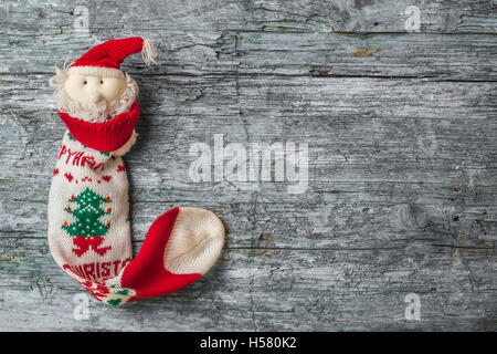 Santa Weihnachtssocke auf rustikalen hölzernen Hintergrund mit Leerzeichen für Text oder Foto Stockfoto