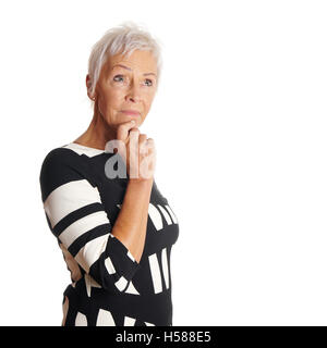 kontemplative ältere Frau nachschlagen Stockfoto