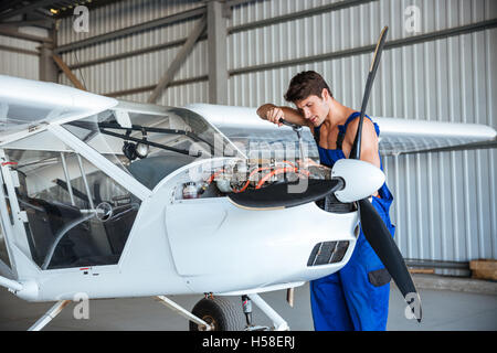 Junge Aircraftsman, die Reparatur von kleiner Flugzeuges konzentriert Stockfoto