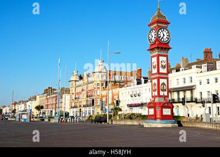 Blick auf Königin Victorias Jubilee Uhrturm an der Esplanade Promenade mit Hotels und Pensionen auf der Rückseite, Weymouth, Großbritannien. Stockfoto