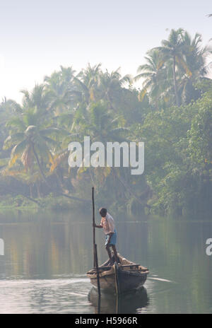 Eine ältere, flache Fischer seinem kleinen Boot durch die Backwaters von Kerala in der Nähe von Koch in Südindien im Morgengrauen Stockfoto