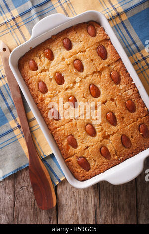 Süße Kuchen mit Mandeln hautnah in Auflaufform auf den Tisch. vertikale Ansicht von oben Stockfoto
