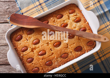 Süße Kuchen Basbousa (Namoora) mit Mandel hautnah in Auflaufform auf den Tisch. horizontale Ansicht von oben Stockfoto