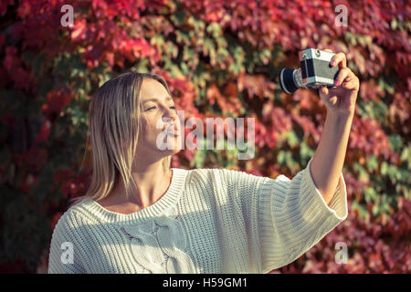 Junge Frau posiert vor der alten Kamera Stockfoto