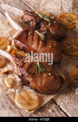 Rustikale Rindersteak mit Zitrone auf dem Papier auf den Tisch-Nahaufnahme. vertikale Stockfoto