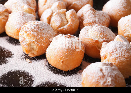 Frisch gebratene Krapfen Castagnole Makro auf einer schwarzen Platte. horizontale Stockfoto