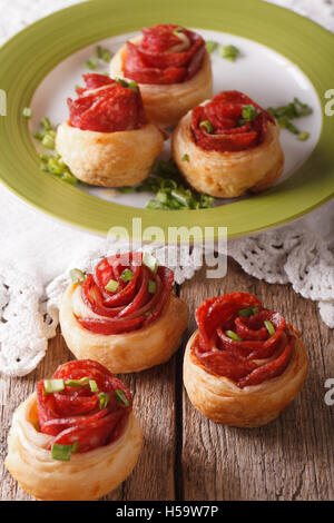 Brötchen mit Salami in Form von Rosen auf dem Tisch. vertikale Stockfoto