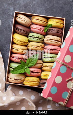 Bunte Macarons in einer Geschenkbox am Steintisch. Süßen Macarons. Ansicht von oben Stockfoto